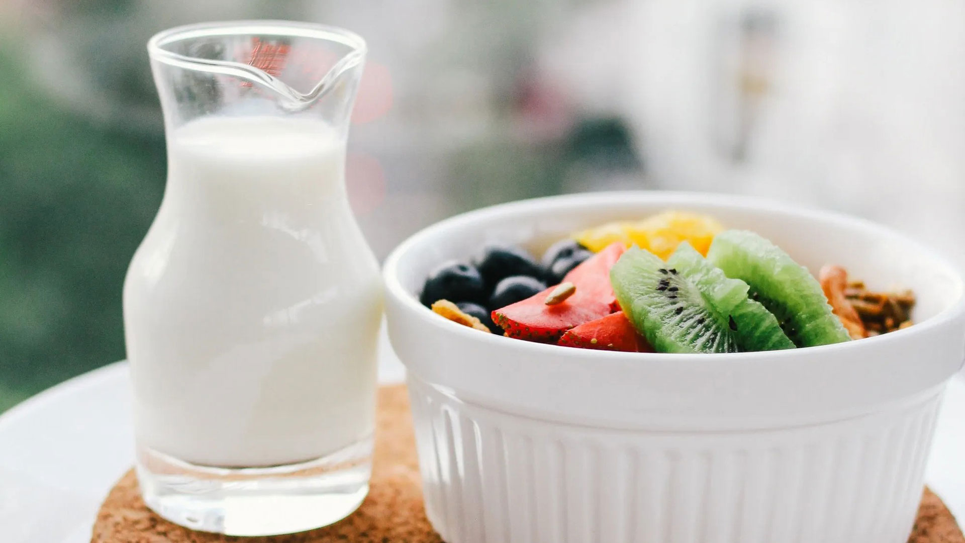 Taça com frutas e jarro com leite